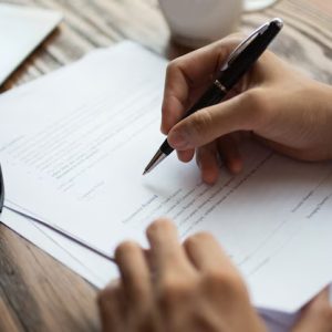Business – Businessman Examining Papers Table
